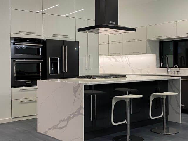 Modern kitchen with marble waterfall island and black matte appliances